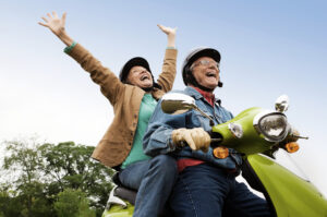 Elderly couple expressing joy on scooter about moving to Hudson WI. www.durhamexecutivegroup.com