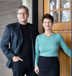 Realtors, John and Becky Durham standing in front of a home. 